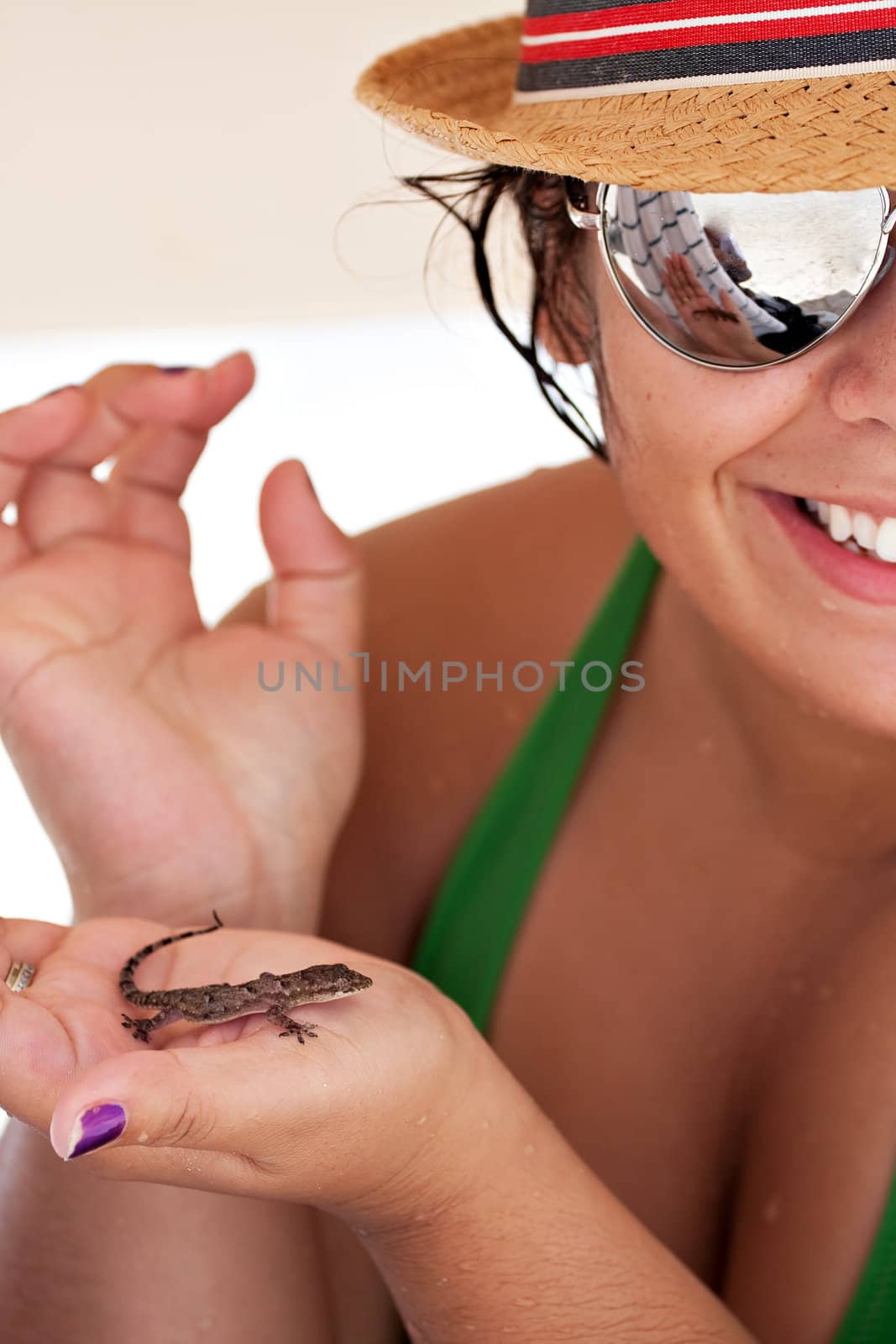 Young Hispanic woman happily holds a wild tropical lizard found on the island of Culebra Puerto Rico. Shallow depth of field.