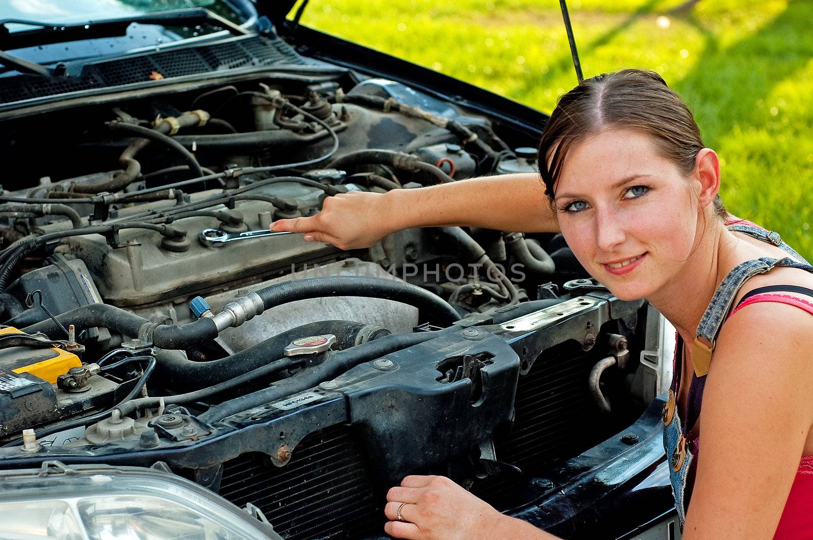 Young woman repairing her car