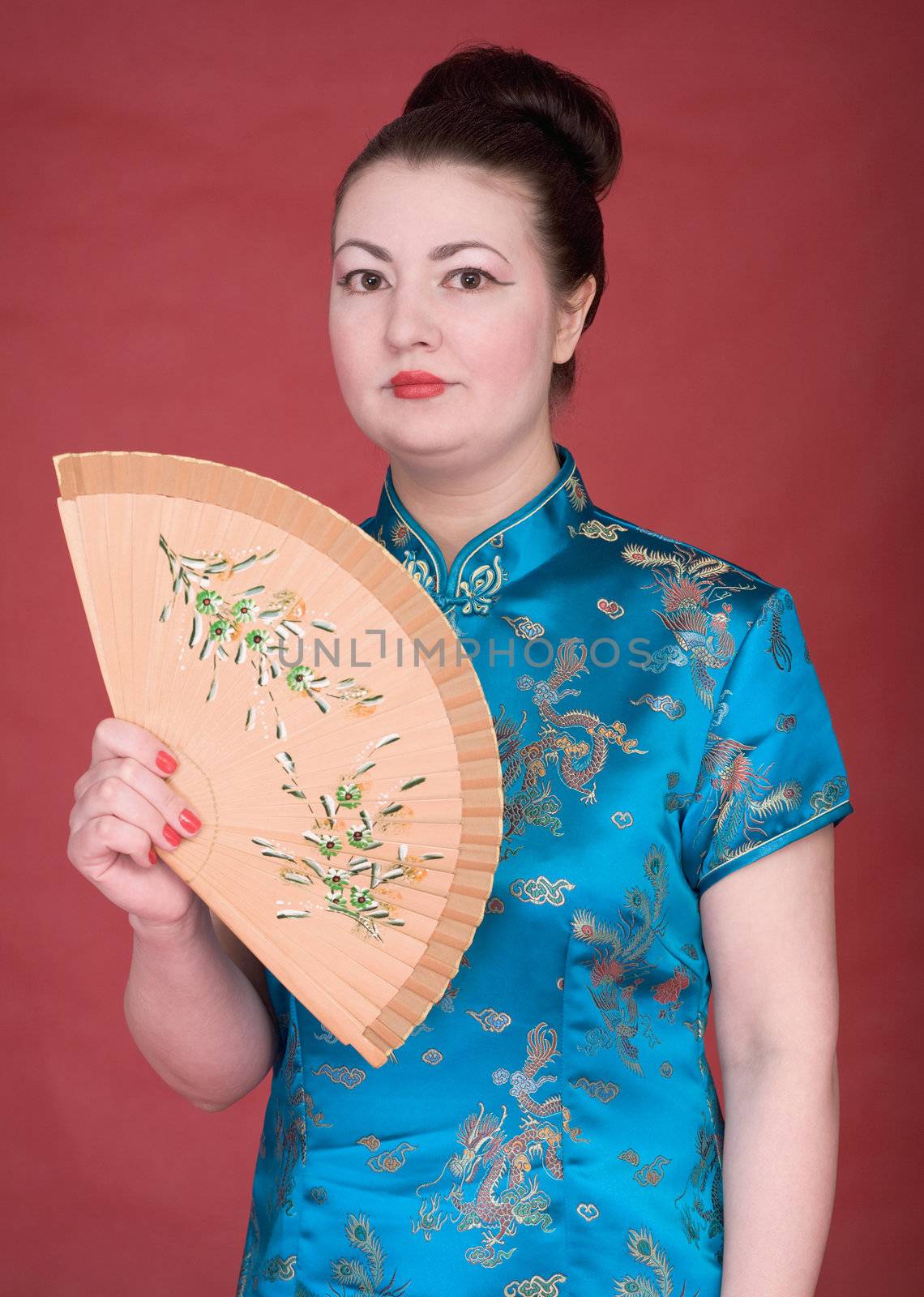 Japanese girl with fan on the red background