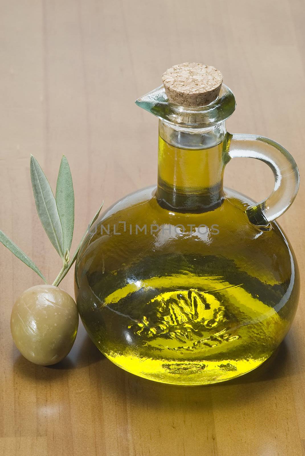 Olive oil bottles and olives on a bamboo mat.