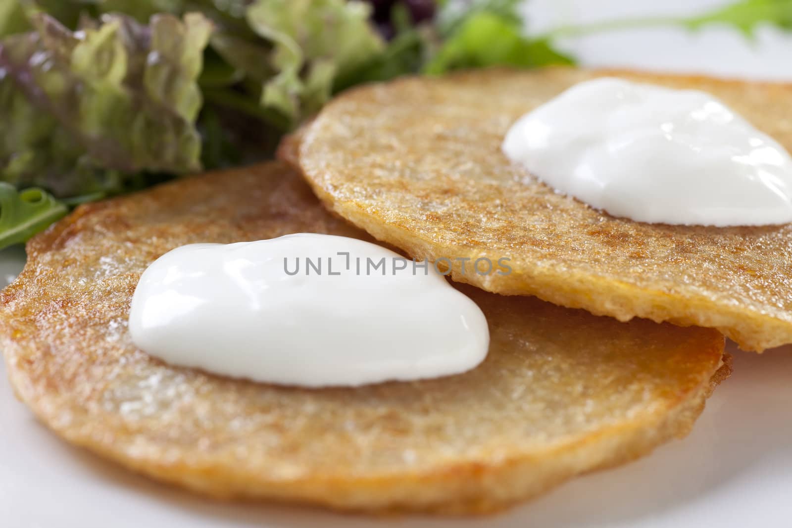 Close up of potato pancakes with sour cream