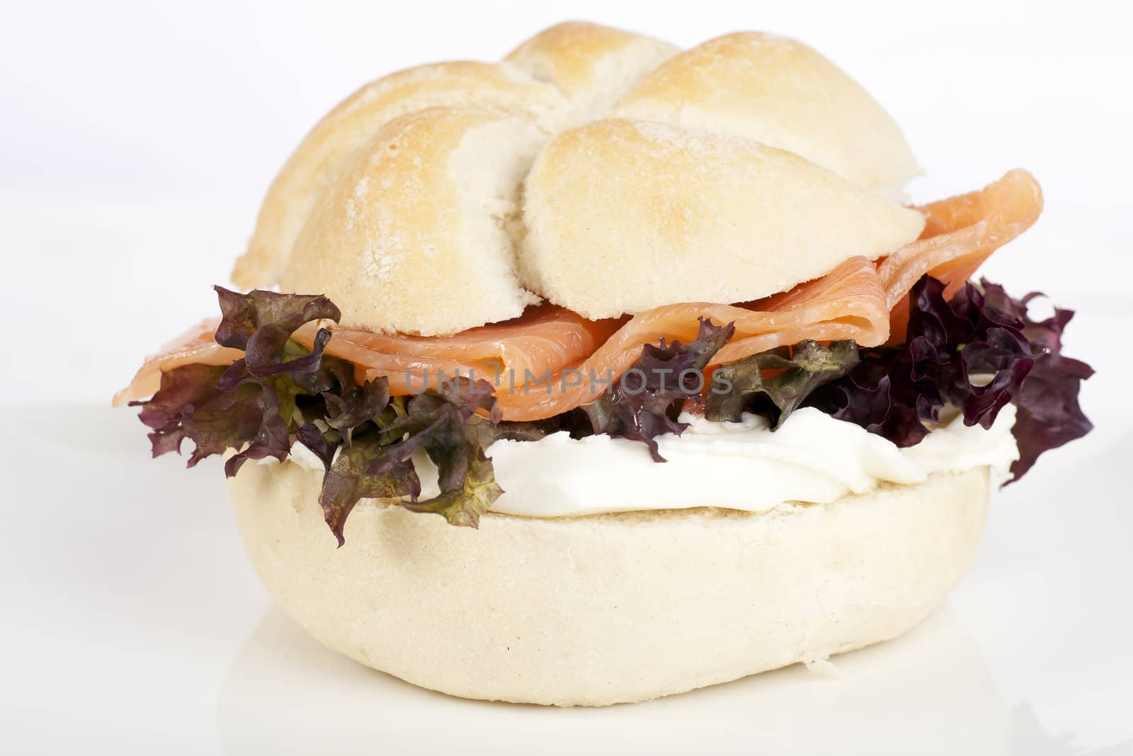 Healthy smoked salmon with cream cheese and salad on kaiser roll.