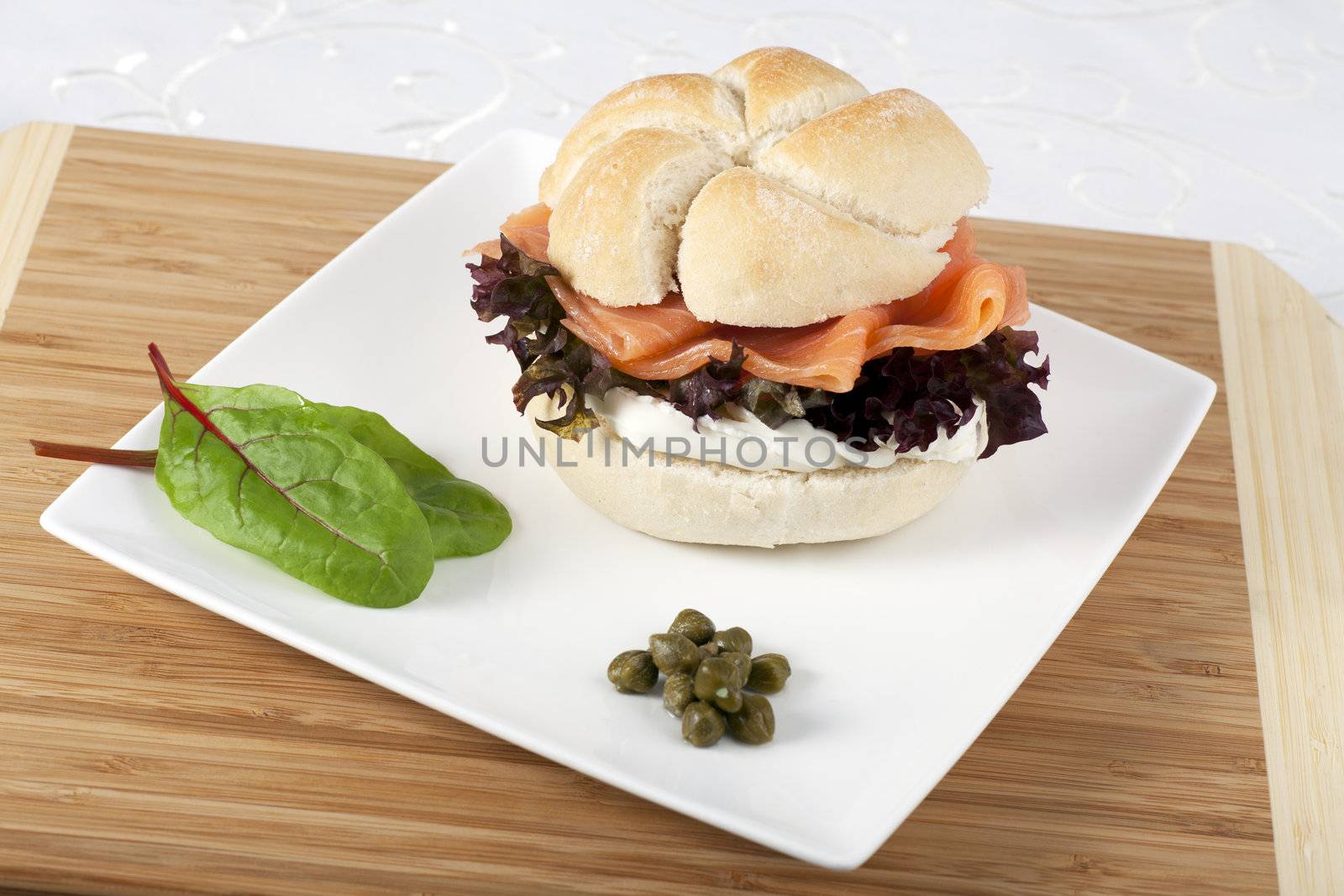 Smoked salmon and cream cheese on roll with capers.