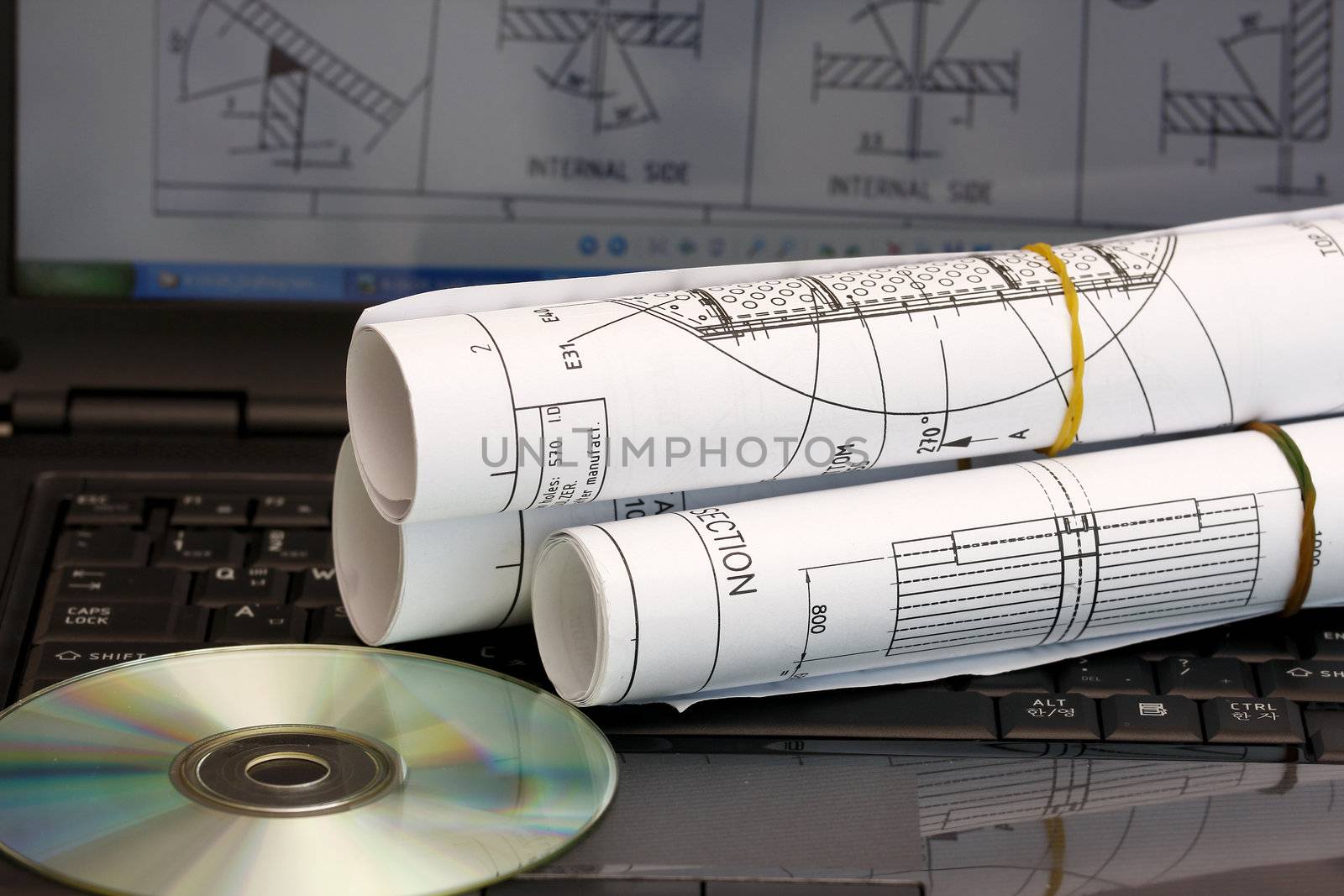 Computer aided design concept - roll of blueprint with CD.