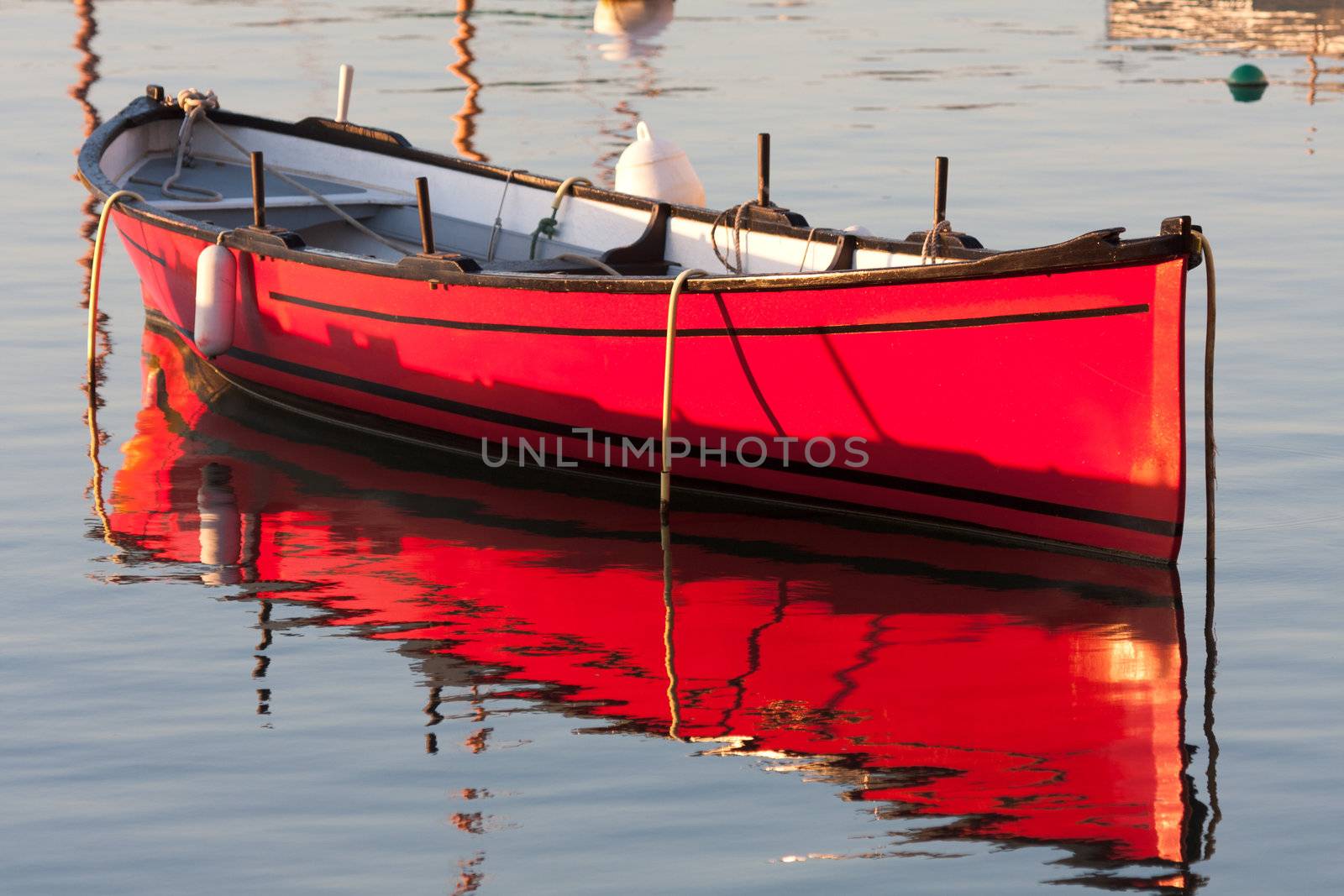 Morning light on a red boat at anchor