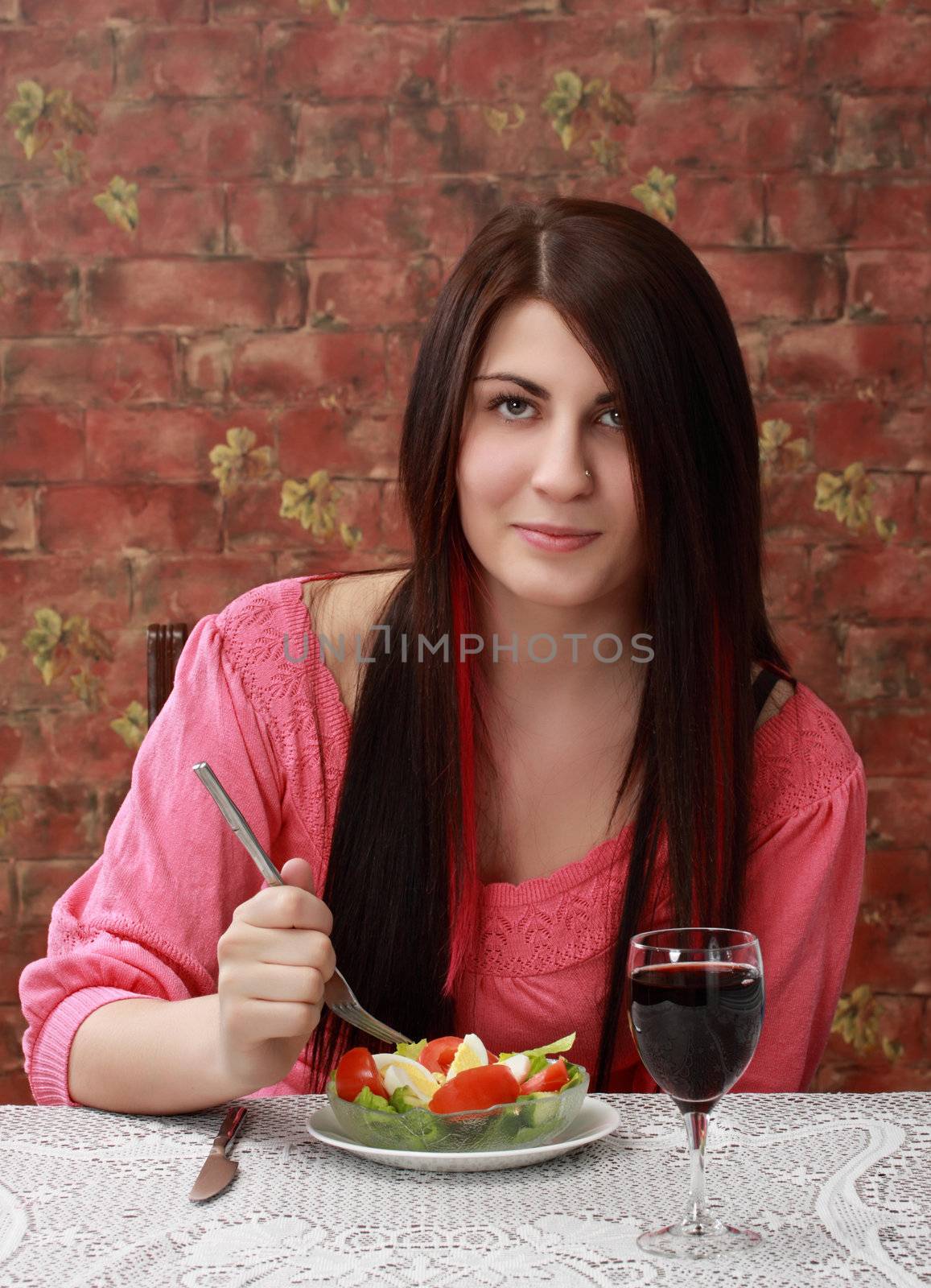 caucasian girl holding a fork, ready to eat fresh salad