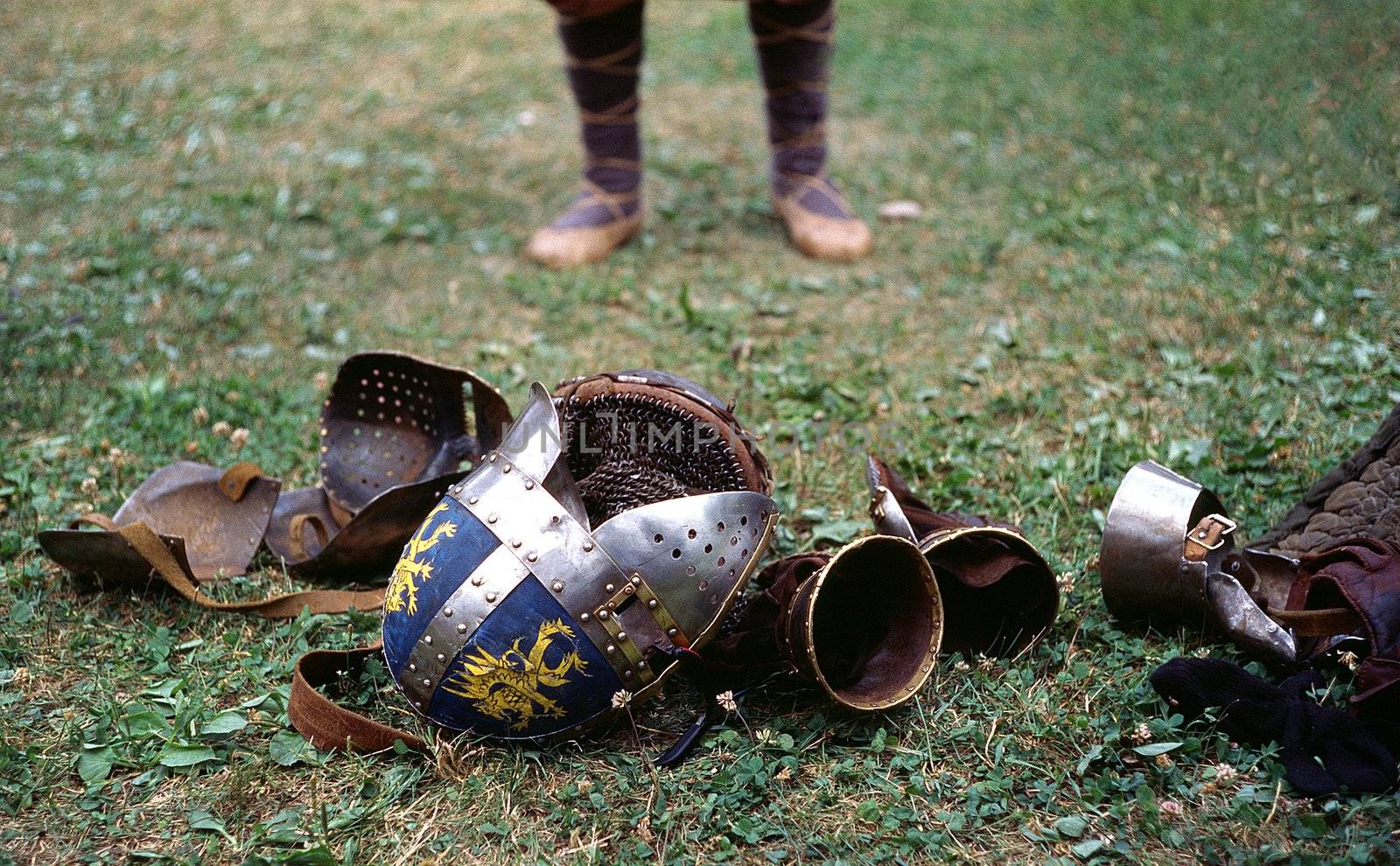 legs in a bast shoes, helmet and armour on the groung after the tournament