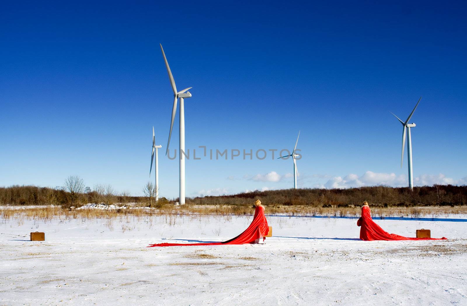 red ladies on snow field with windmills
