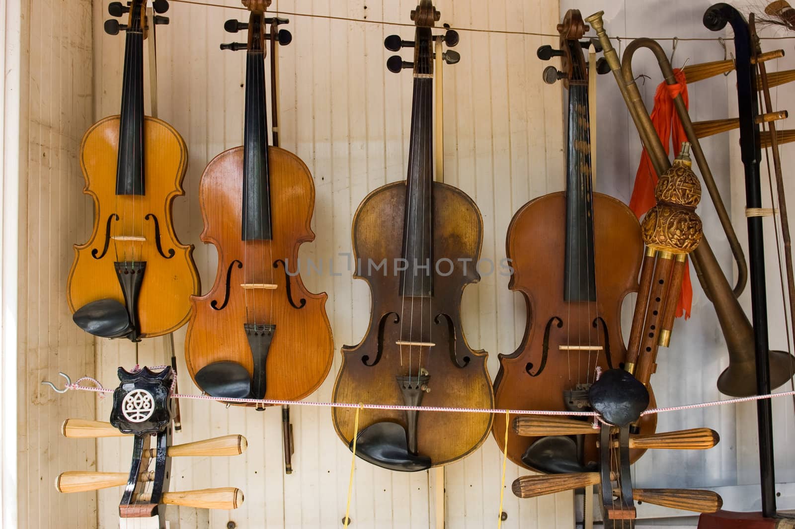 4 hanging violins at flea market