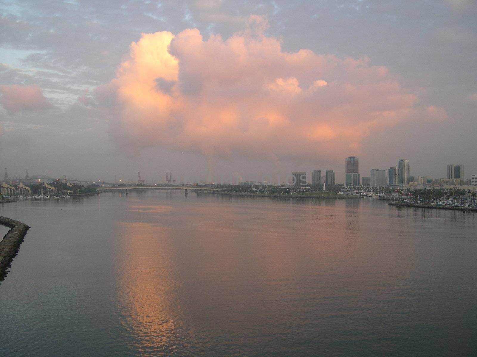 a cloud at sunset, also the reflection in the water, in a harbor