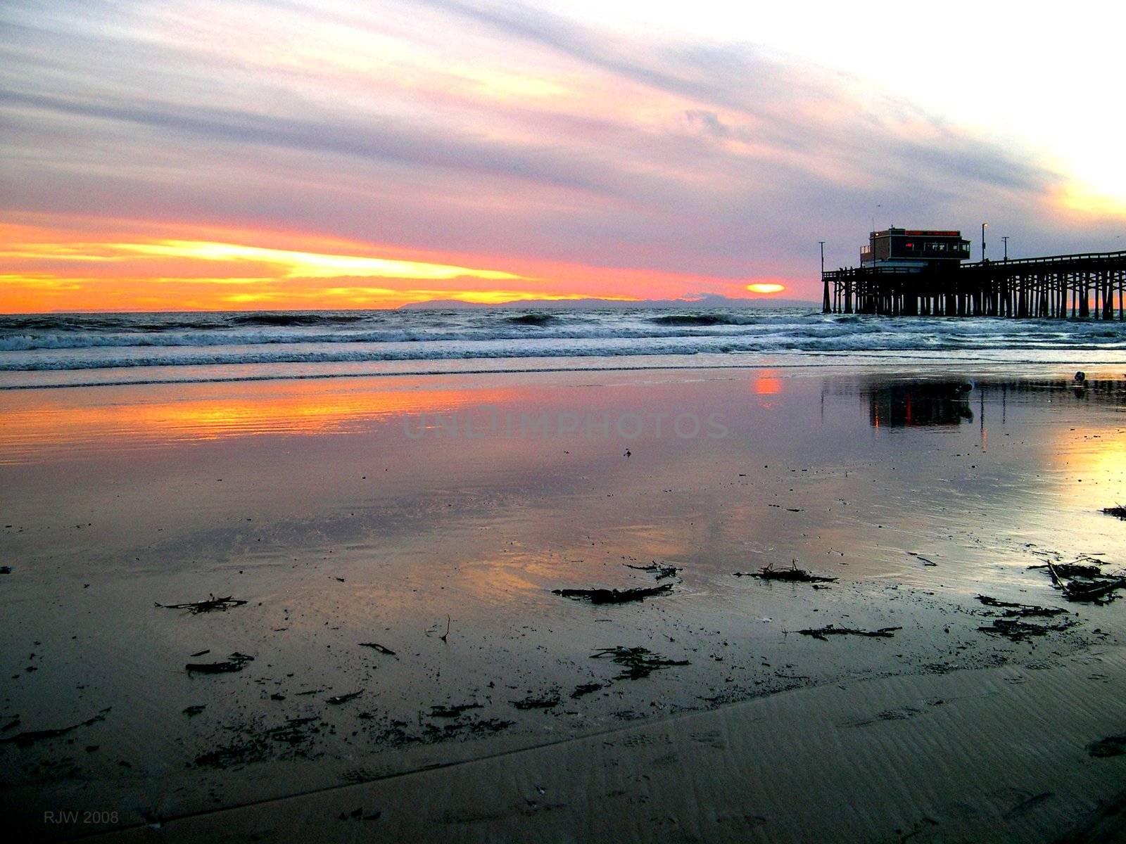 reflection of a pier in the ocean at sunset