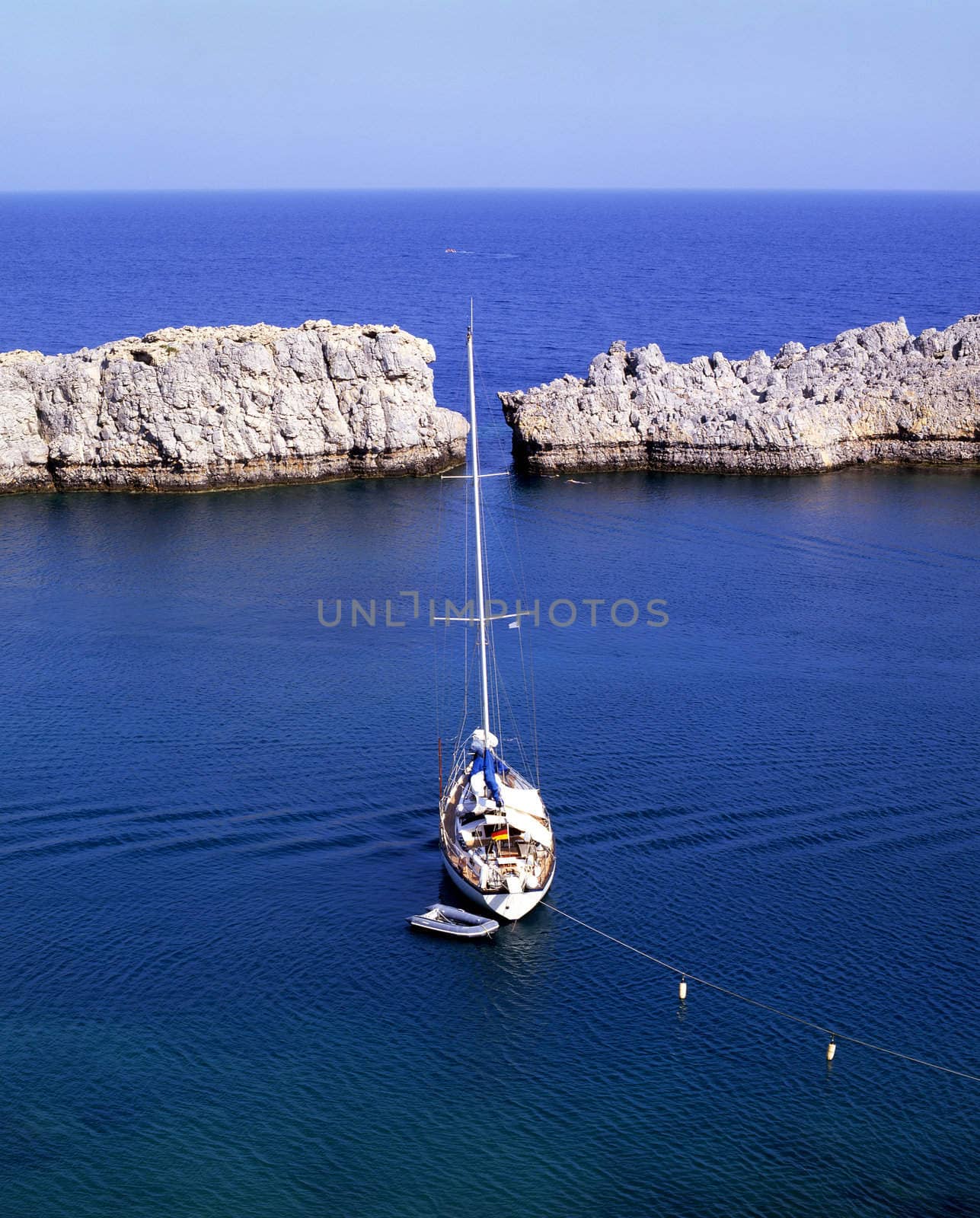 Sailboat moored off the coast of the village of Lindos on the greek island of Rhodes