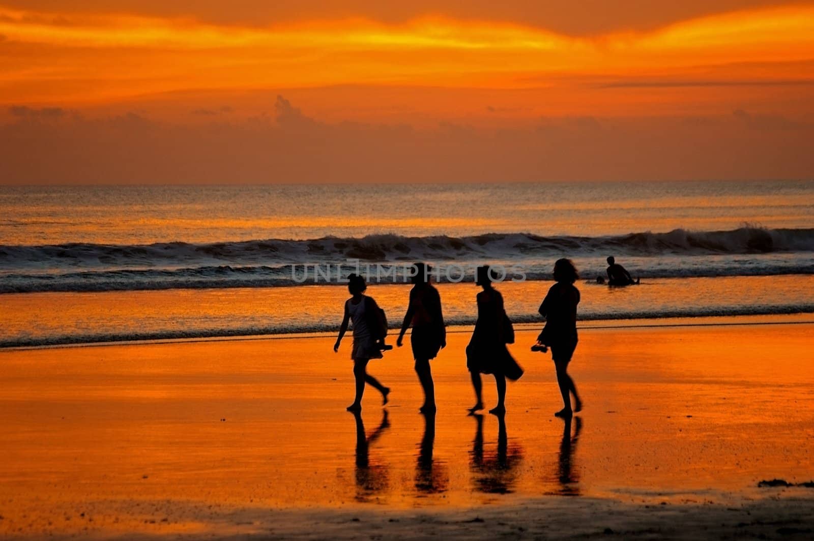 Female backpackers taking a stroll on Double Six beach, Seminyak, Bali, Indonesia.