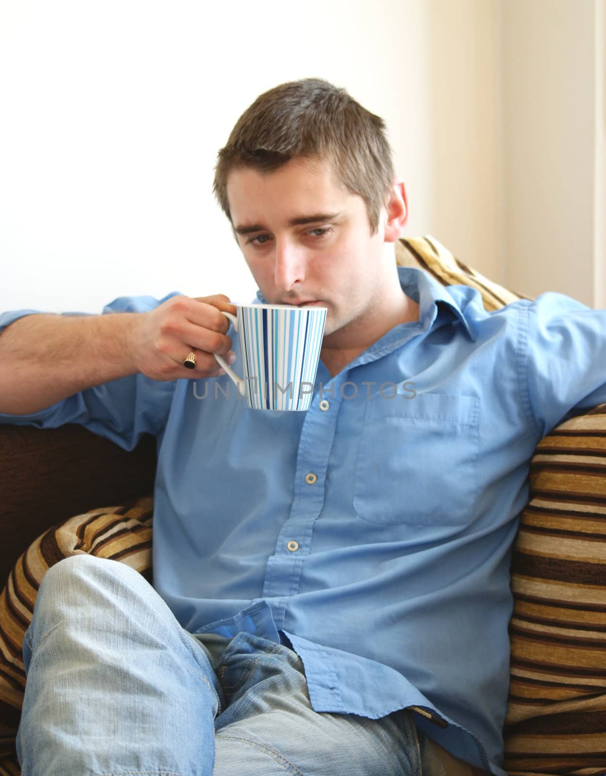 a man in a blue shirt drinking coffee