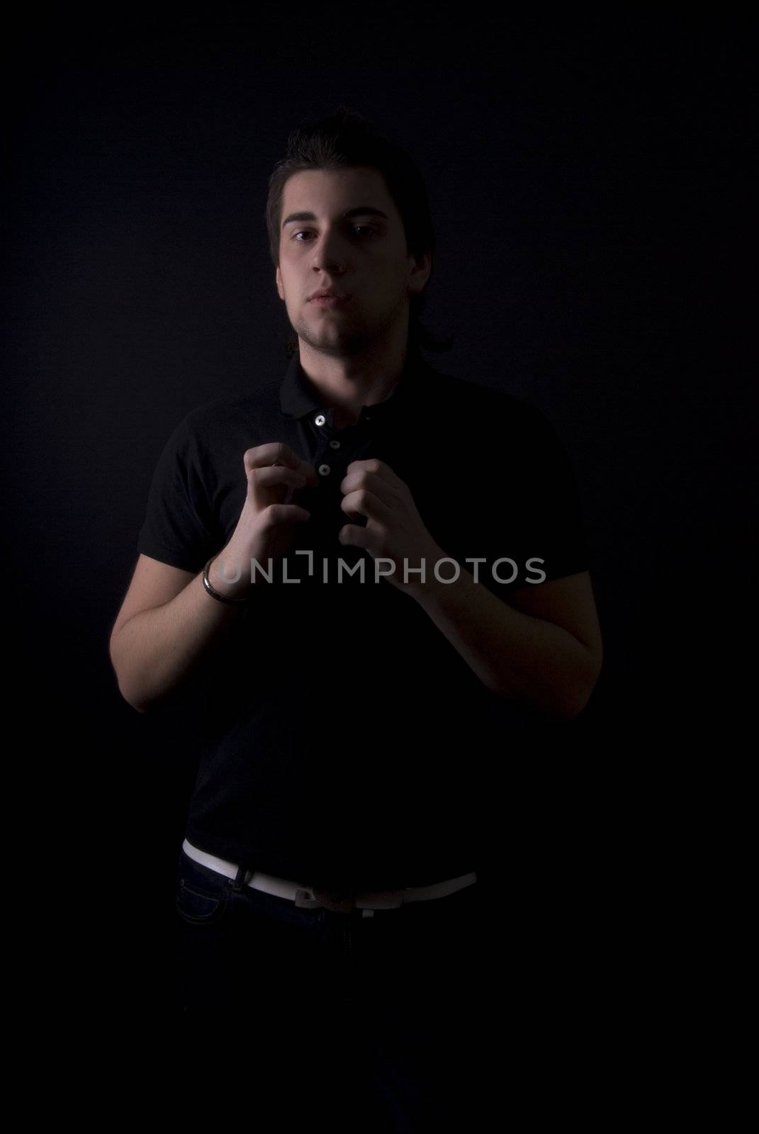 portrait of the young dark-haired  man in darkness 