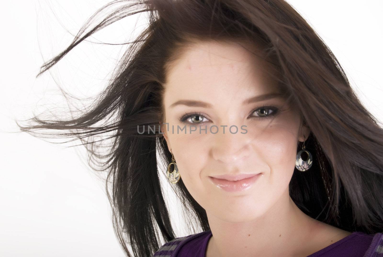 Portrait of a young beautiful brunette with the hair blowing about