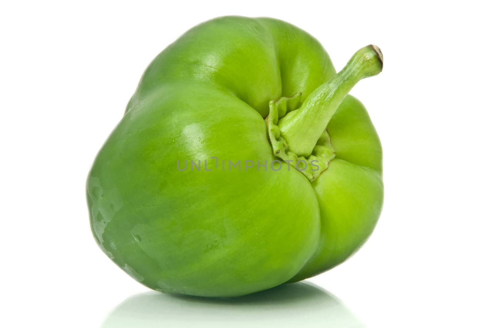 Close and low level capturing single isolated green bell pepper over white.