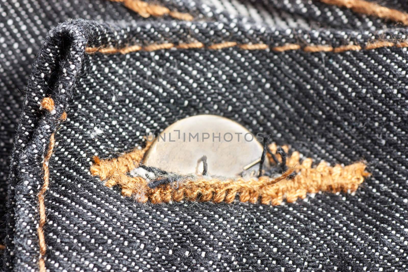 Closeup view of half clasped button on a jeans