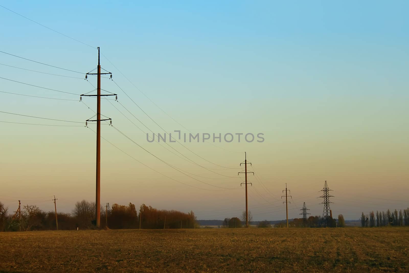 Pylons in the countryside. Autumn, the setting time