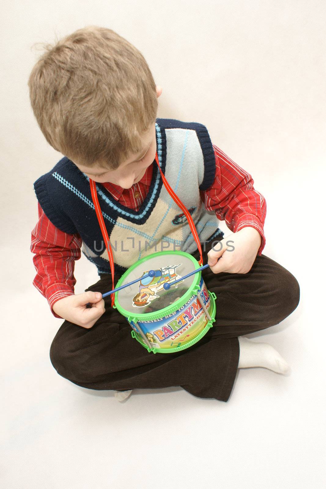 young boy with drums in white background