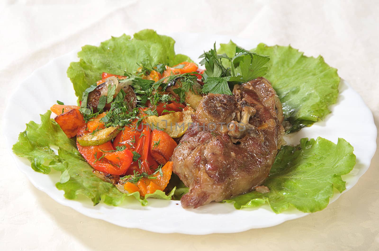 hot dish of a bird with green-stuffs and greenery on a white dish