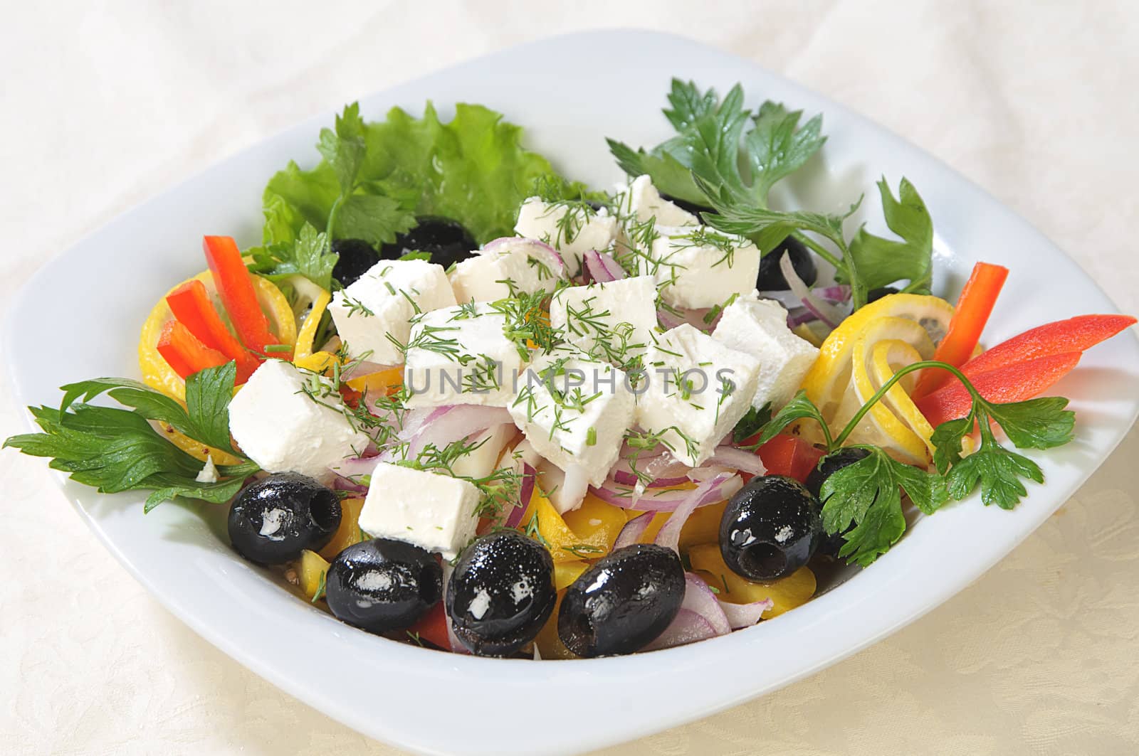 Slices of cheese in a salad of feta cheese and diced vegetables