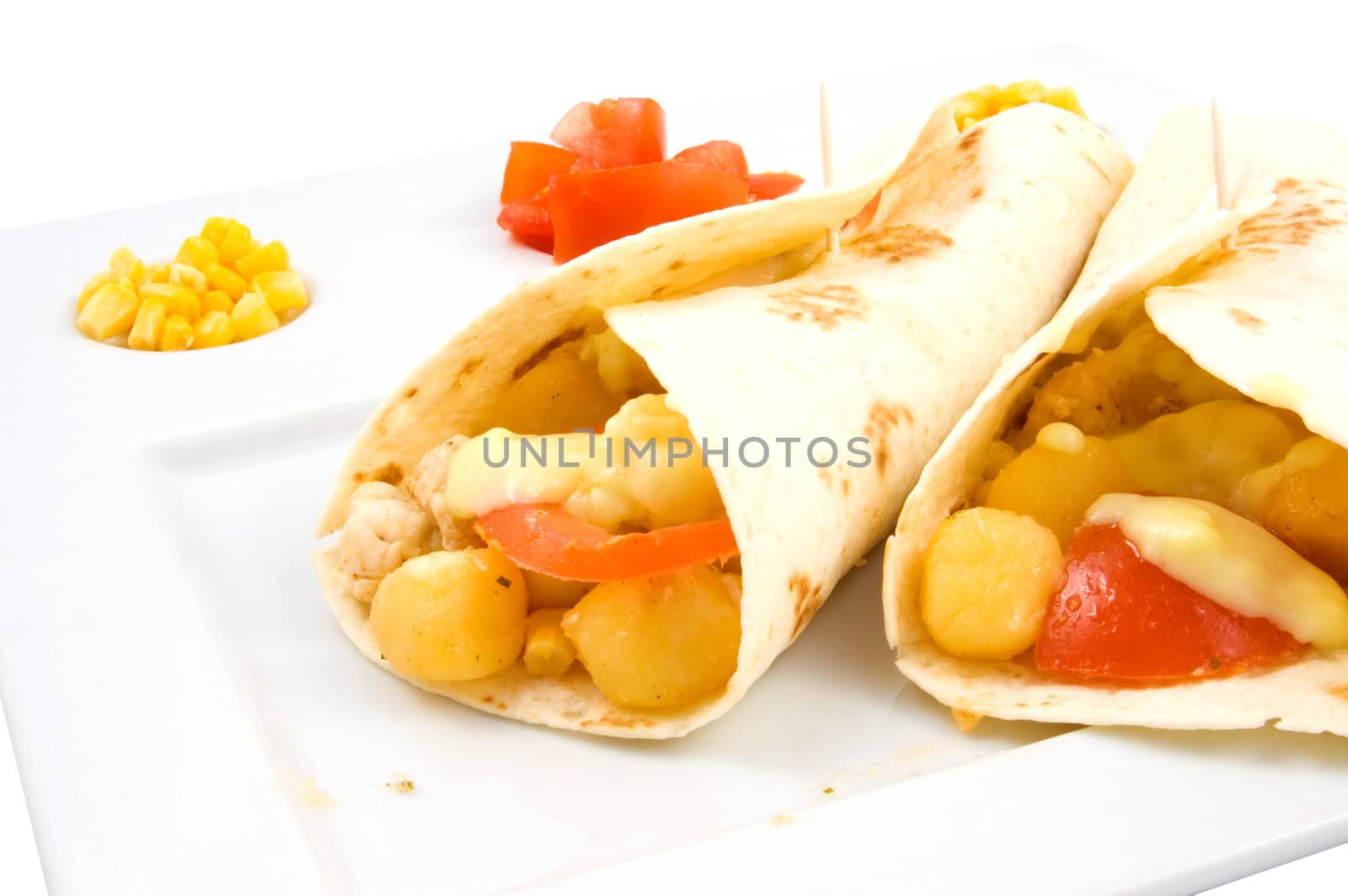 white plate with filled wraps laying on it isolated