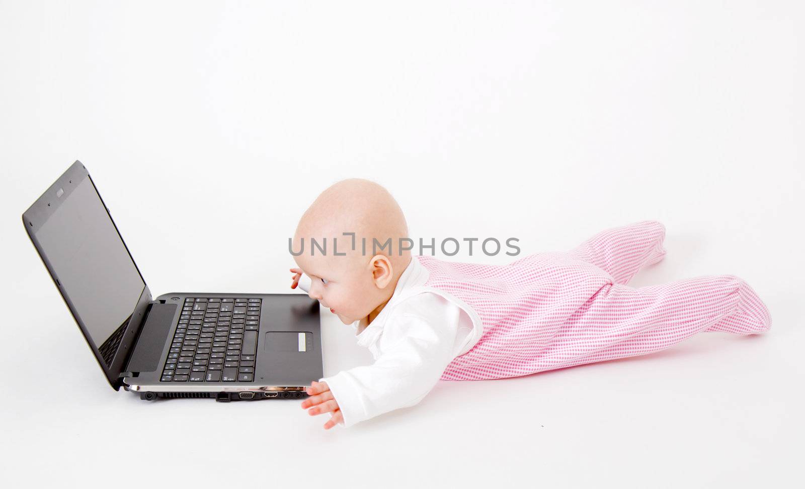 baby with laptop on a white background in studio
