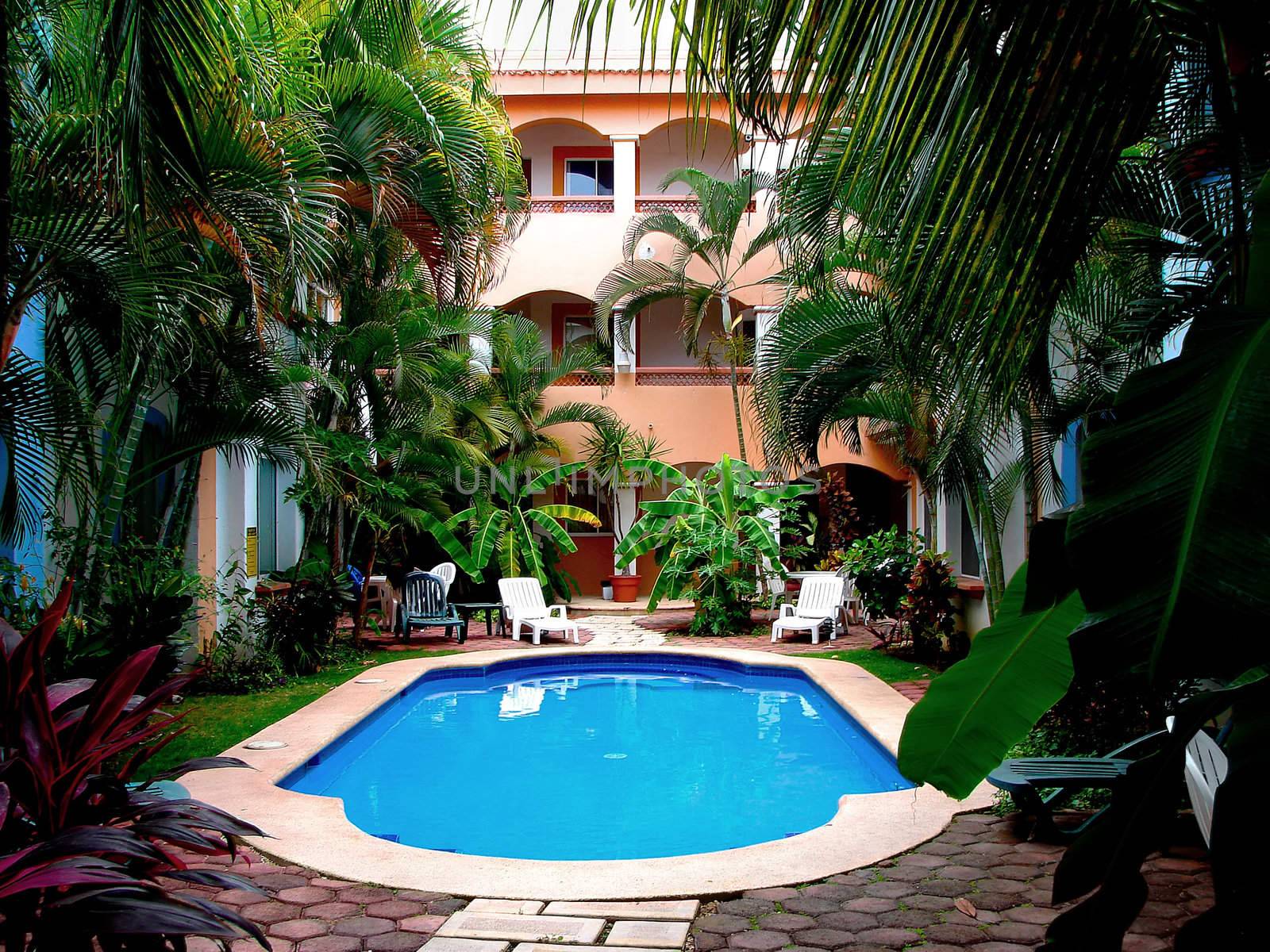Courtyard of tropical condos with superb blue water pool, inviting destination.