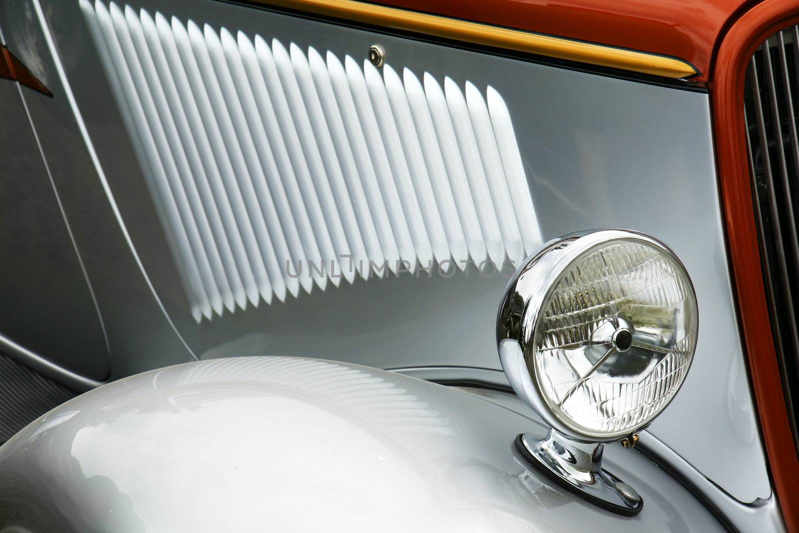 Detail of old silver collectible car,cool light reflections.
