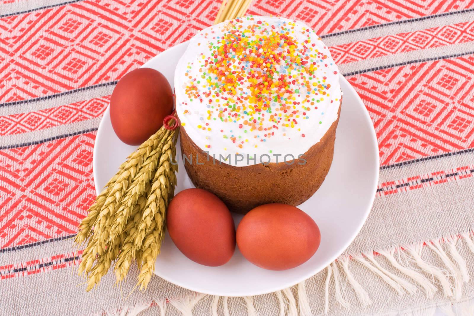 Easter Cake, Painted Eggs and Ears of Wheat on traditional tablecloth