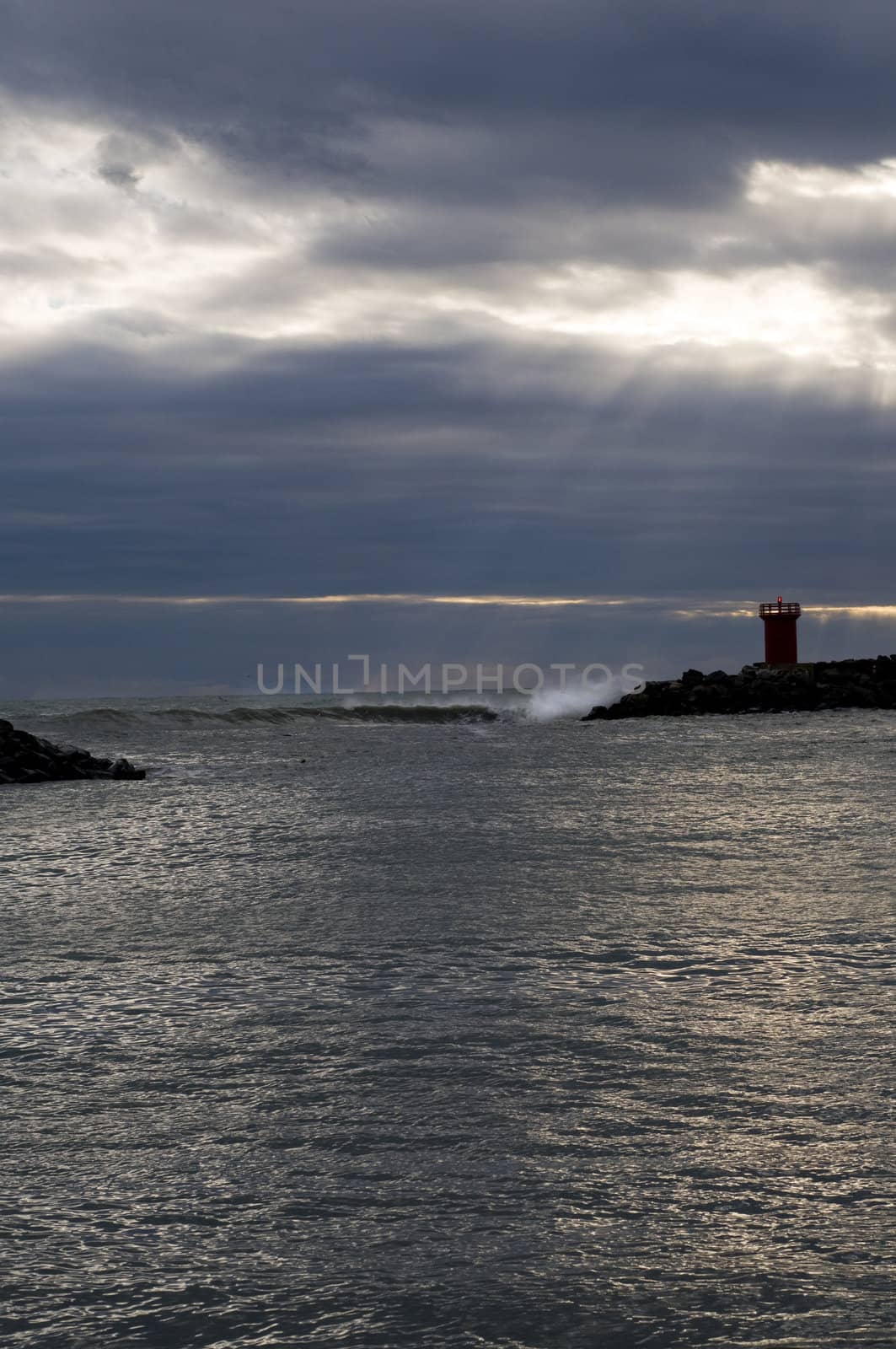 Wave on rock - light in winter sea