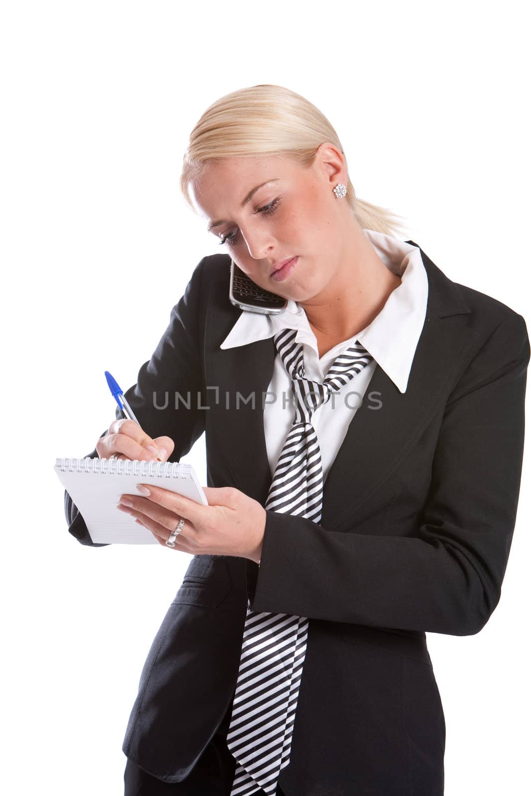 Beautiful business woman making notes while on the phone