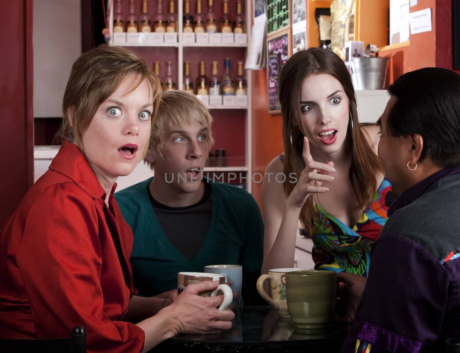 Four friends having an animated discussion in a coffee house