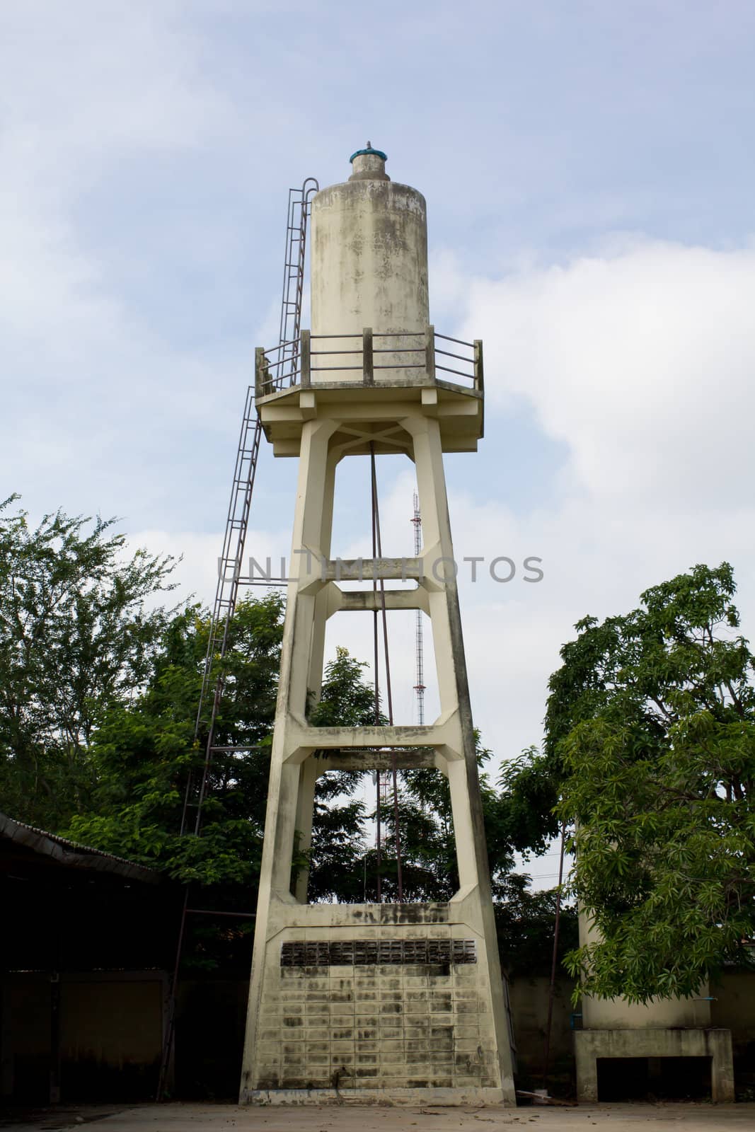 Old abandoned industrial water tower with reservoir tank by lavoview