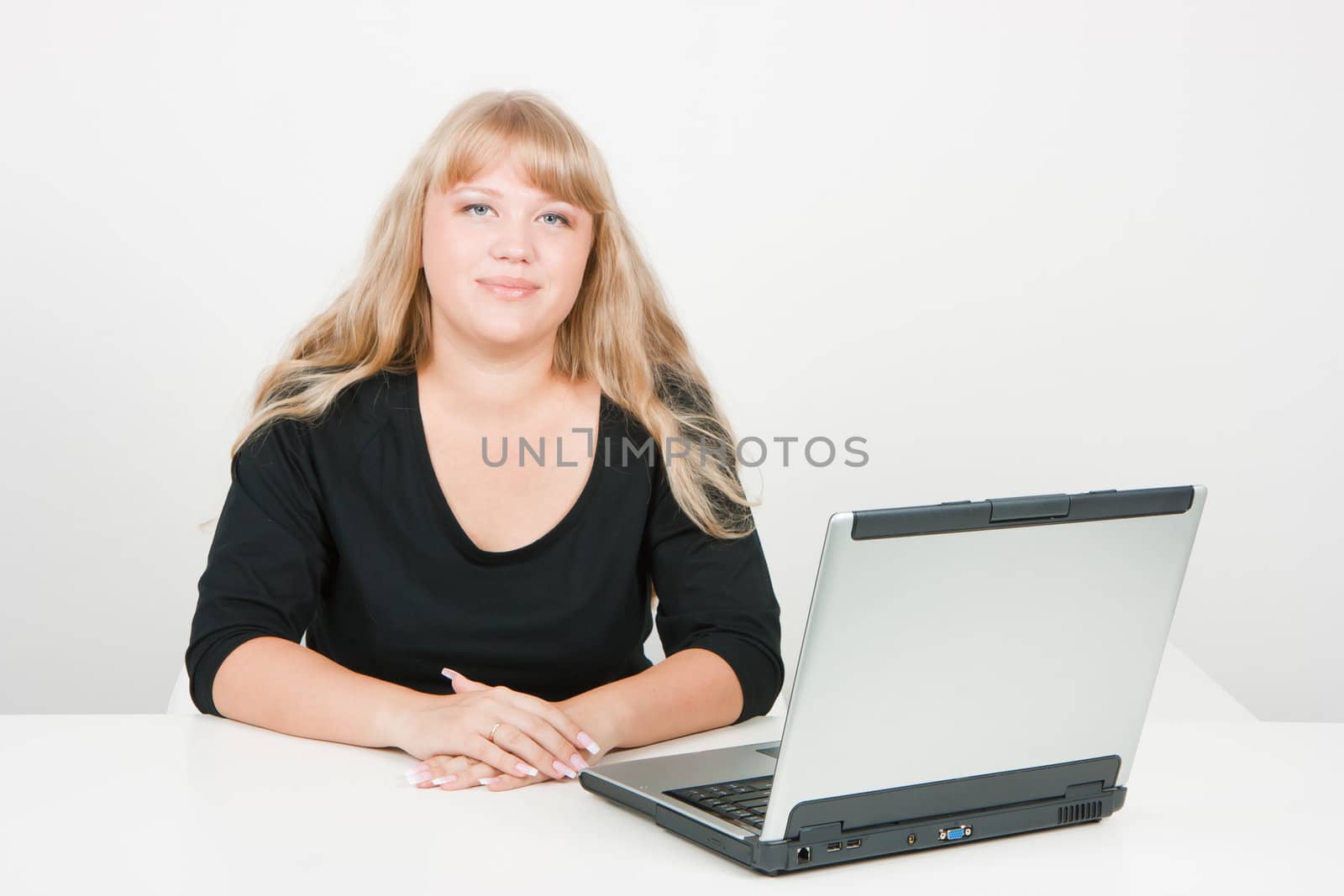 a young girl working on laptop in a bright room
