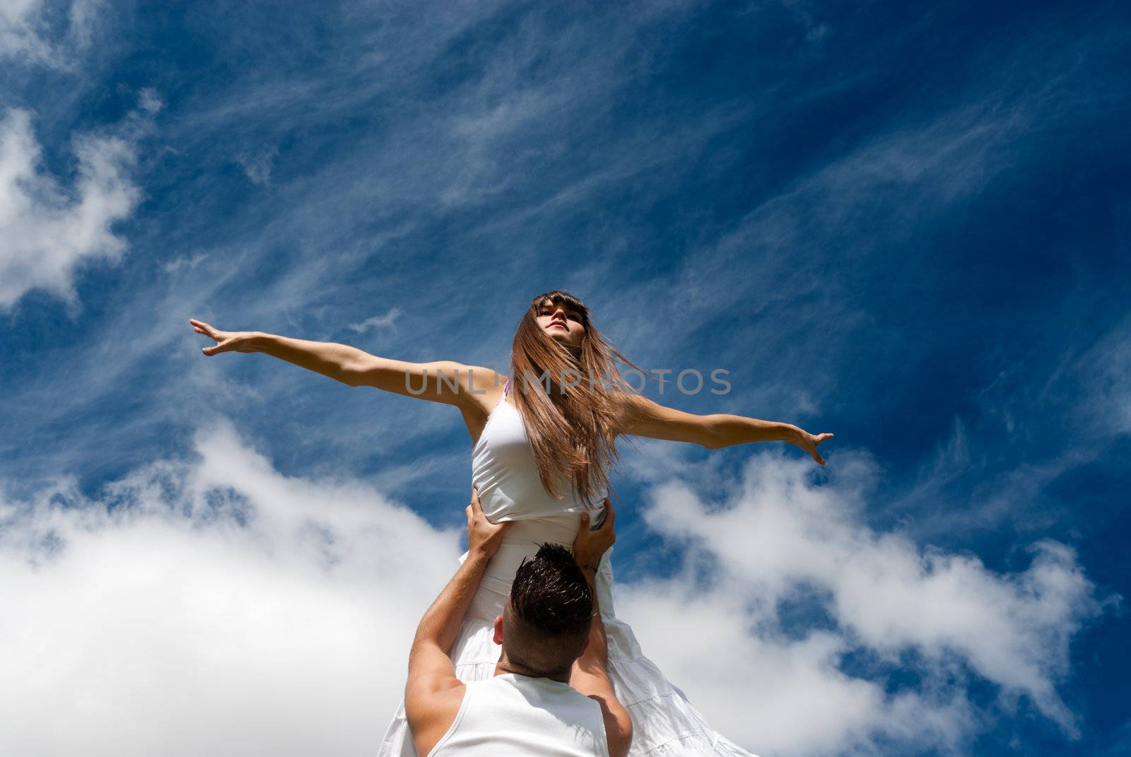 young couple dancing on sky background, freedom and relax symbol  by dgmata