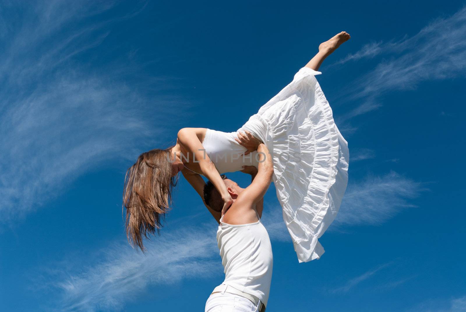 young couple dancing on sky background, freedom and relax symbol 