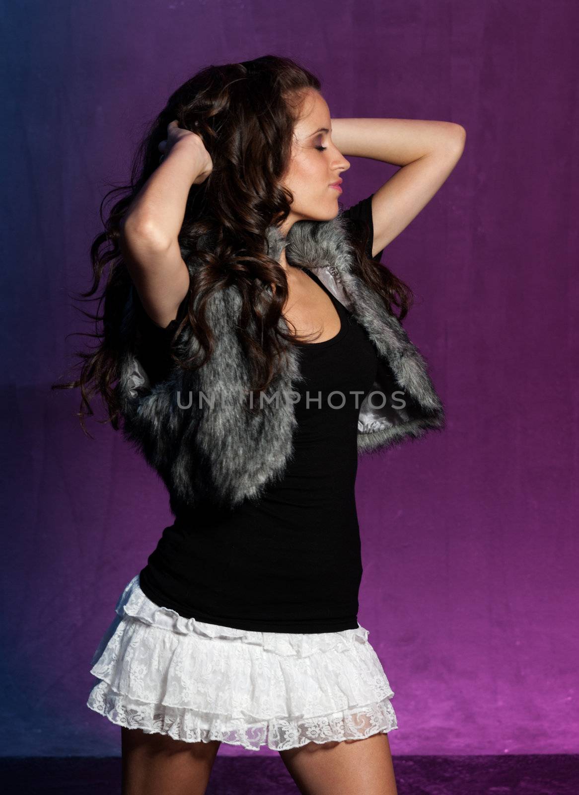 Young girl dancing on blue and purple background. 