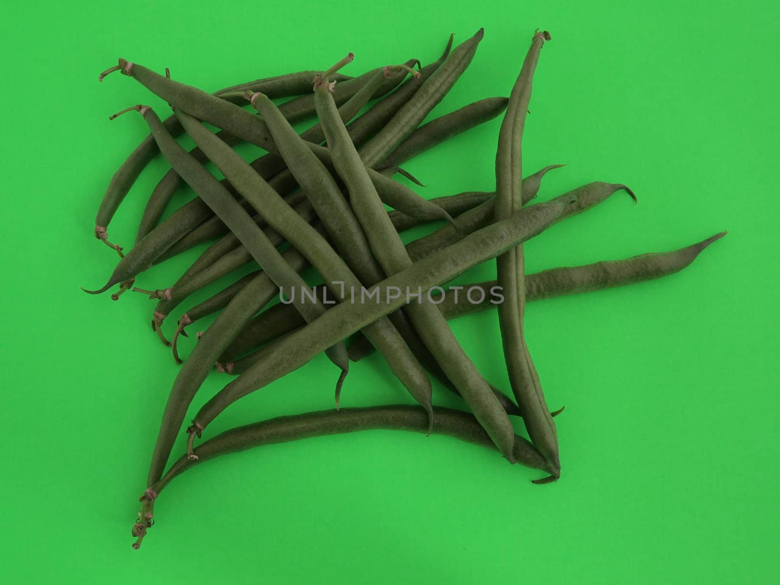 Closeup of organic  runner beans on a green background.