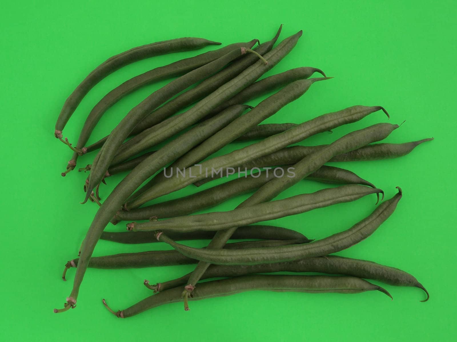 Closeup of organic runner beans on a green background.