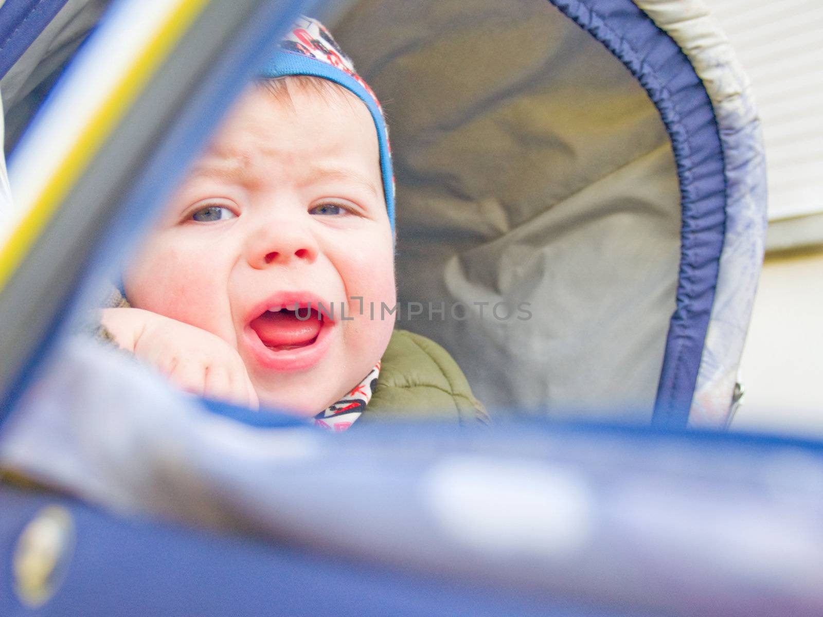 Caucasian baby boy crying in his stroller