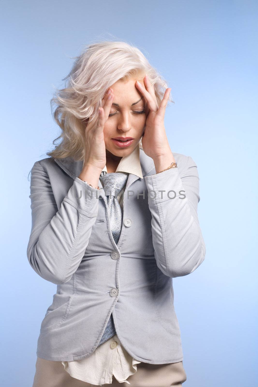 Beautyful blond woman with headache on blue background