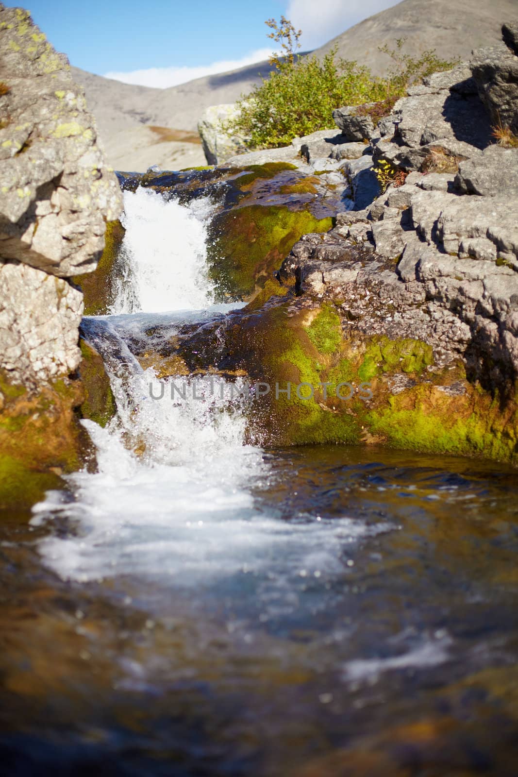 Alpine waterfall on a small transparent pure stream