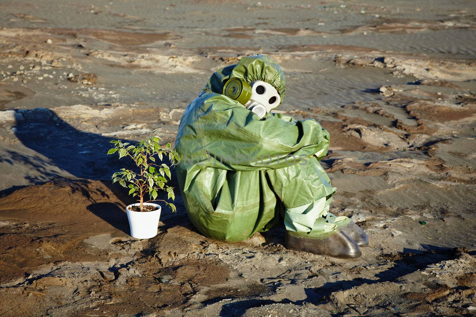 Man in chemical suit and houseplant in desert by pzaxe