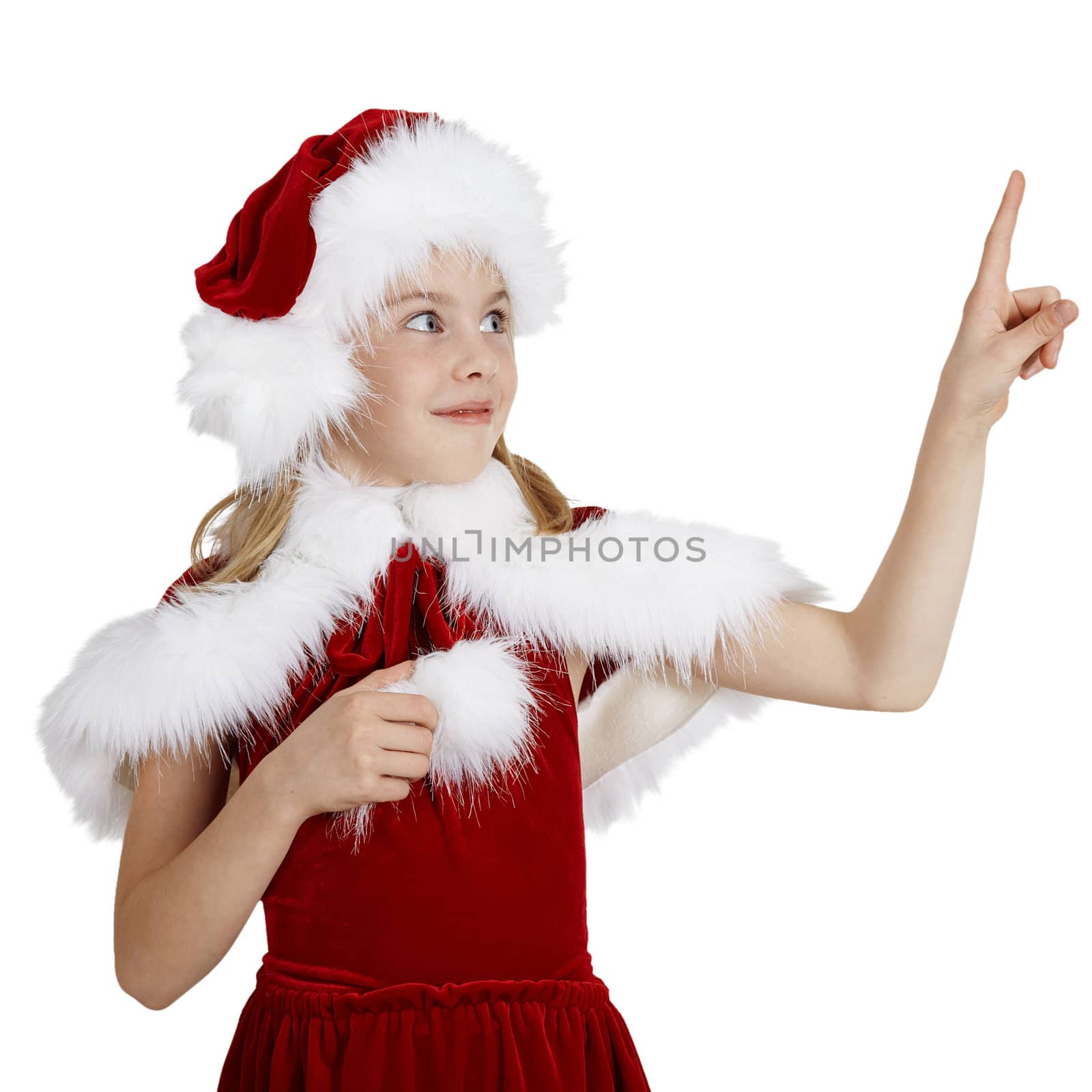 The surprised smiling girl in Christmas clothes points a finger, isolated on a white background