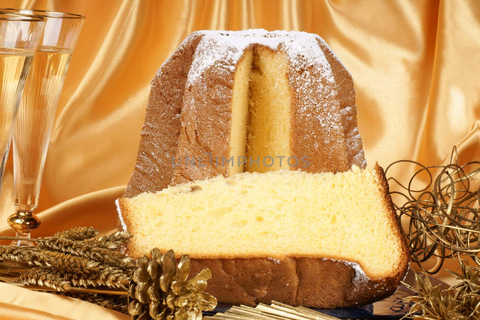 Christmas composition with Pandoro the golden cake of Verona, two glasses of spumante and some ornaments over a yellow background