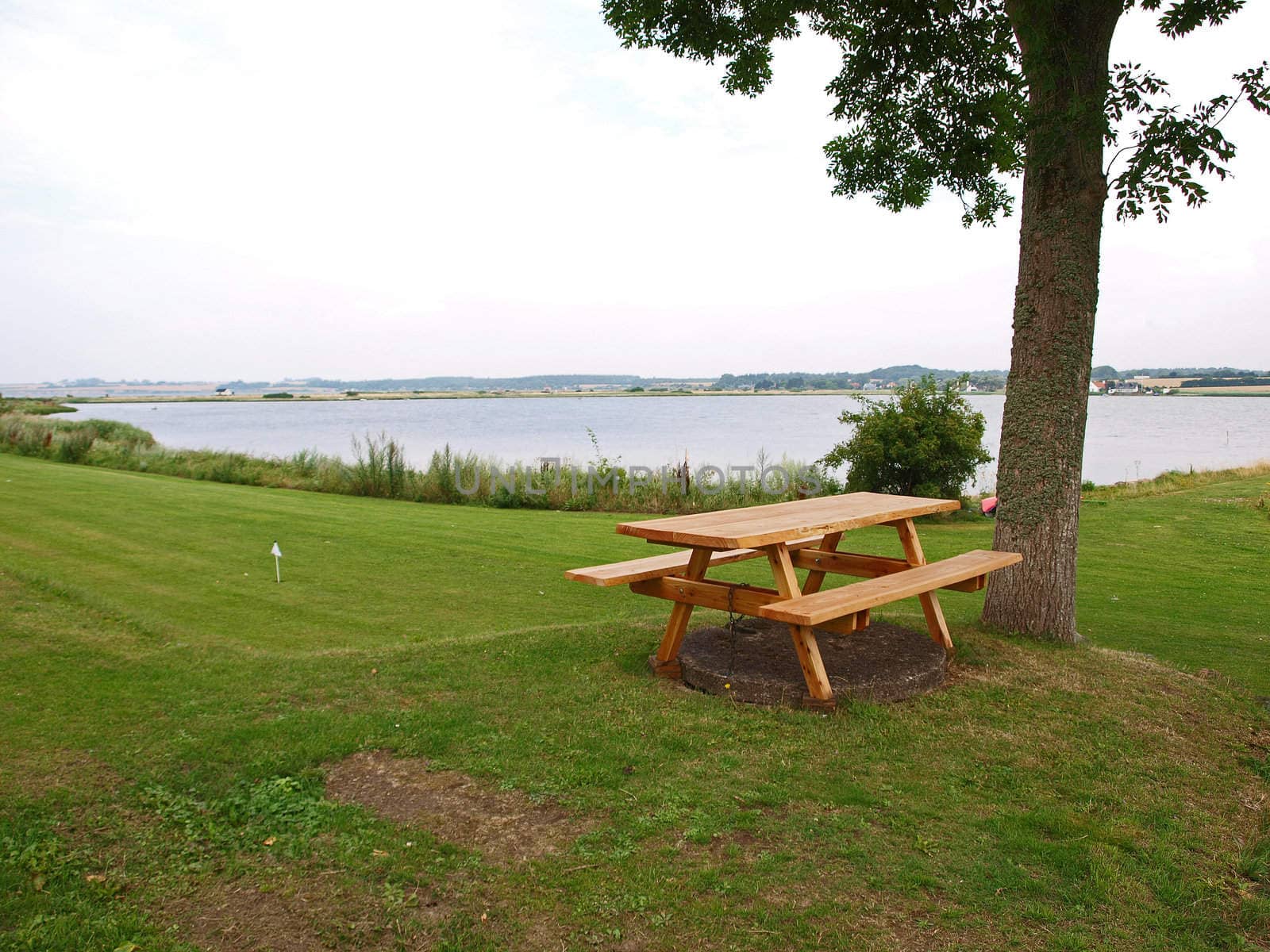 Perfect outdoors picnic setting by the sea with wooden tables  