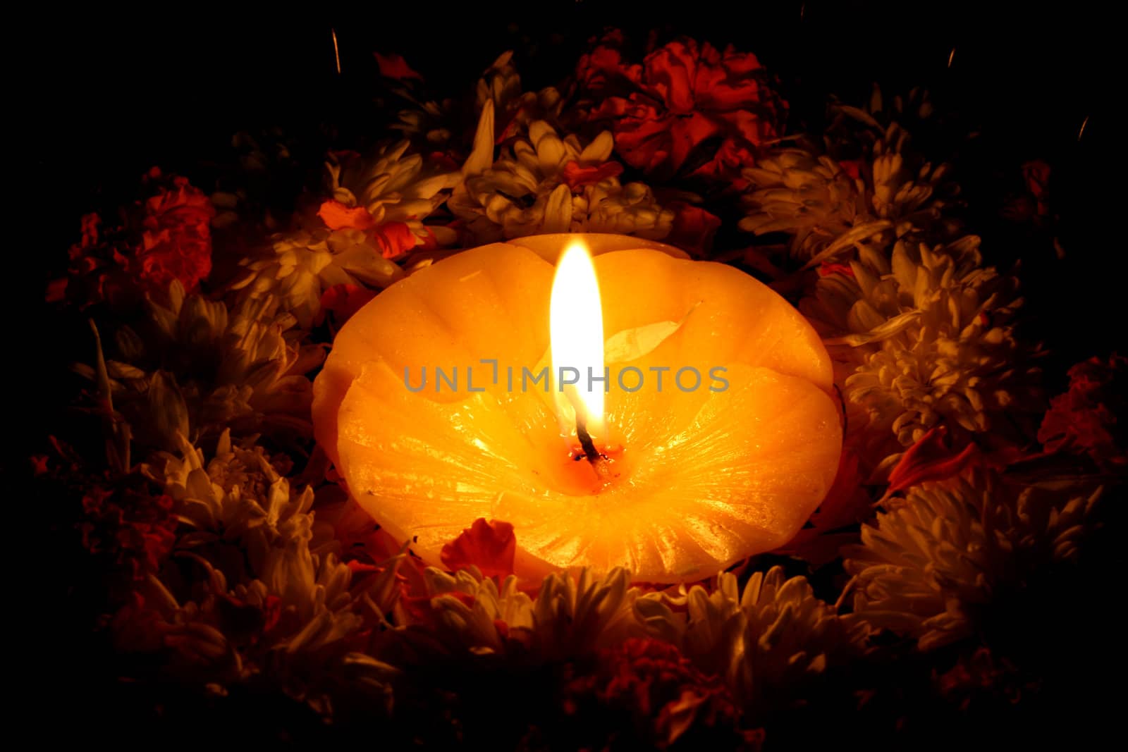 A holy candle surrounded by flowers for traditional Diwali festival rituals.