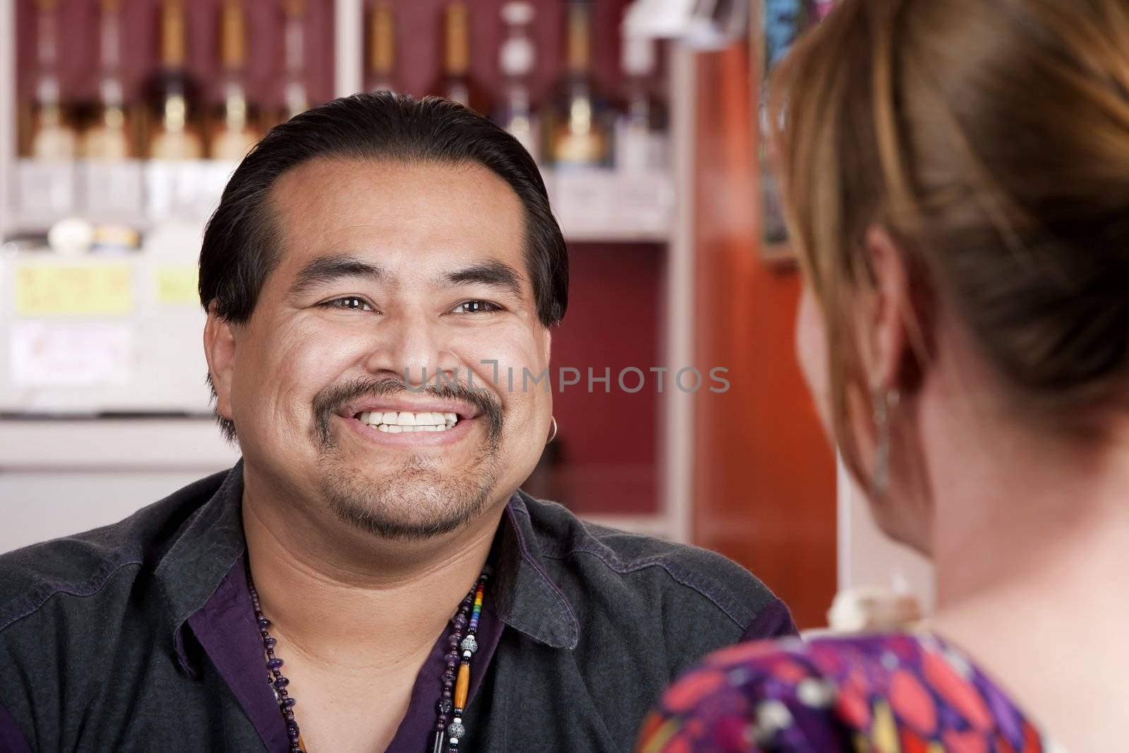 Native American man with female friend in restaurant by Creatista